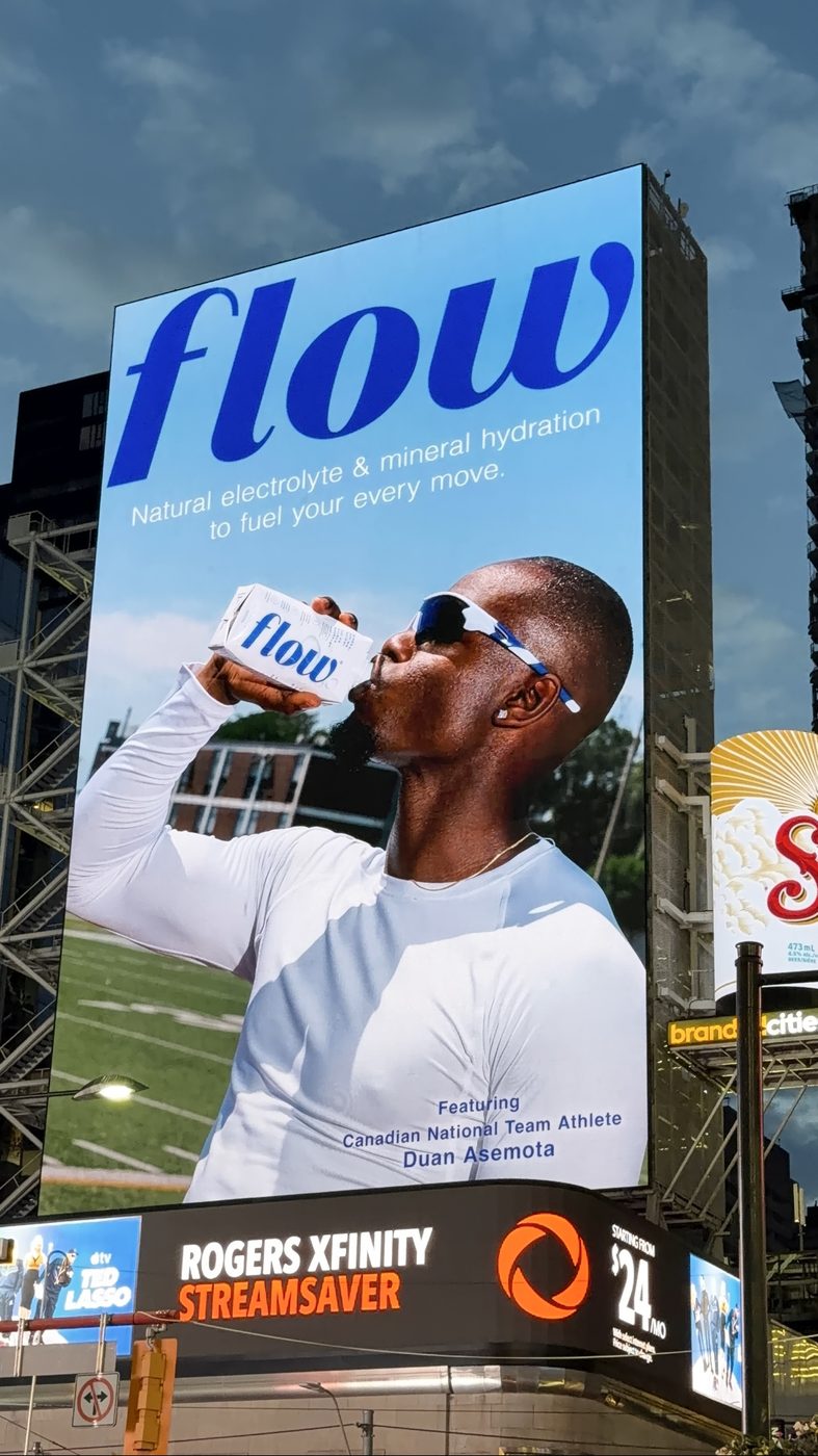 Flow Water billboard at Sankofa Square in downtown Toronto featuring Duan Asemota drinking Flow Water
