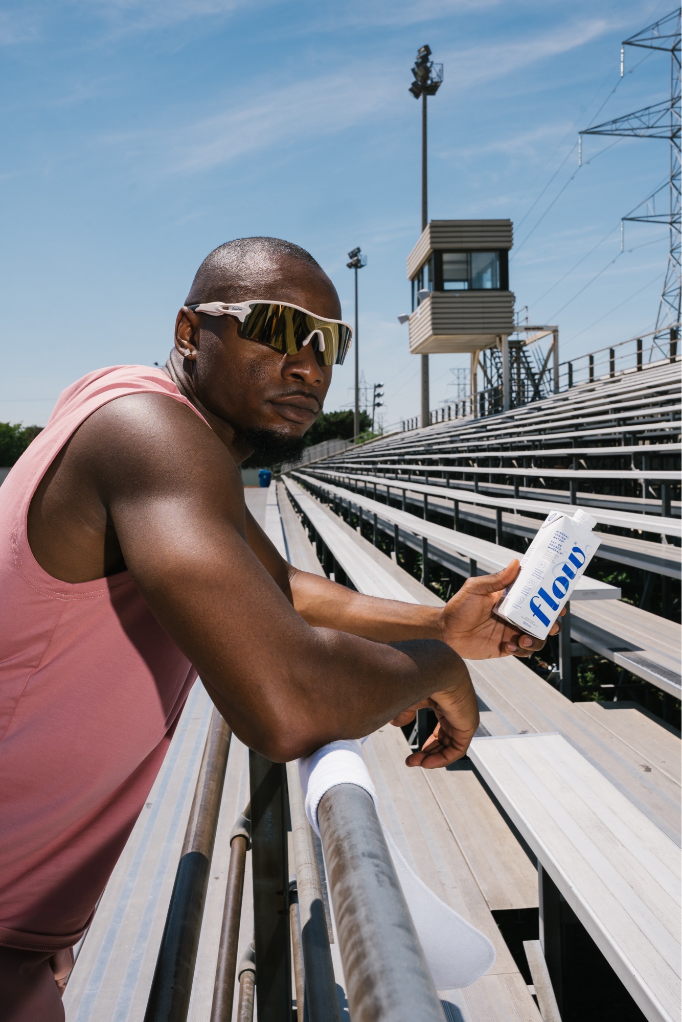 Leaning on a bleacher rail with Flow Water