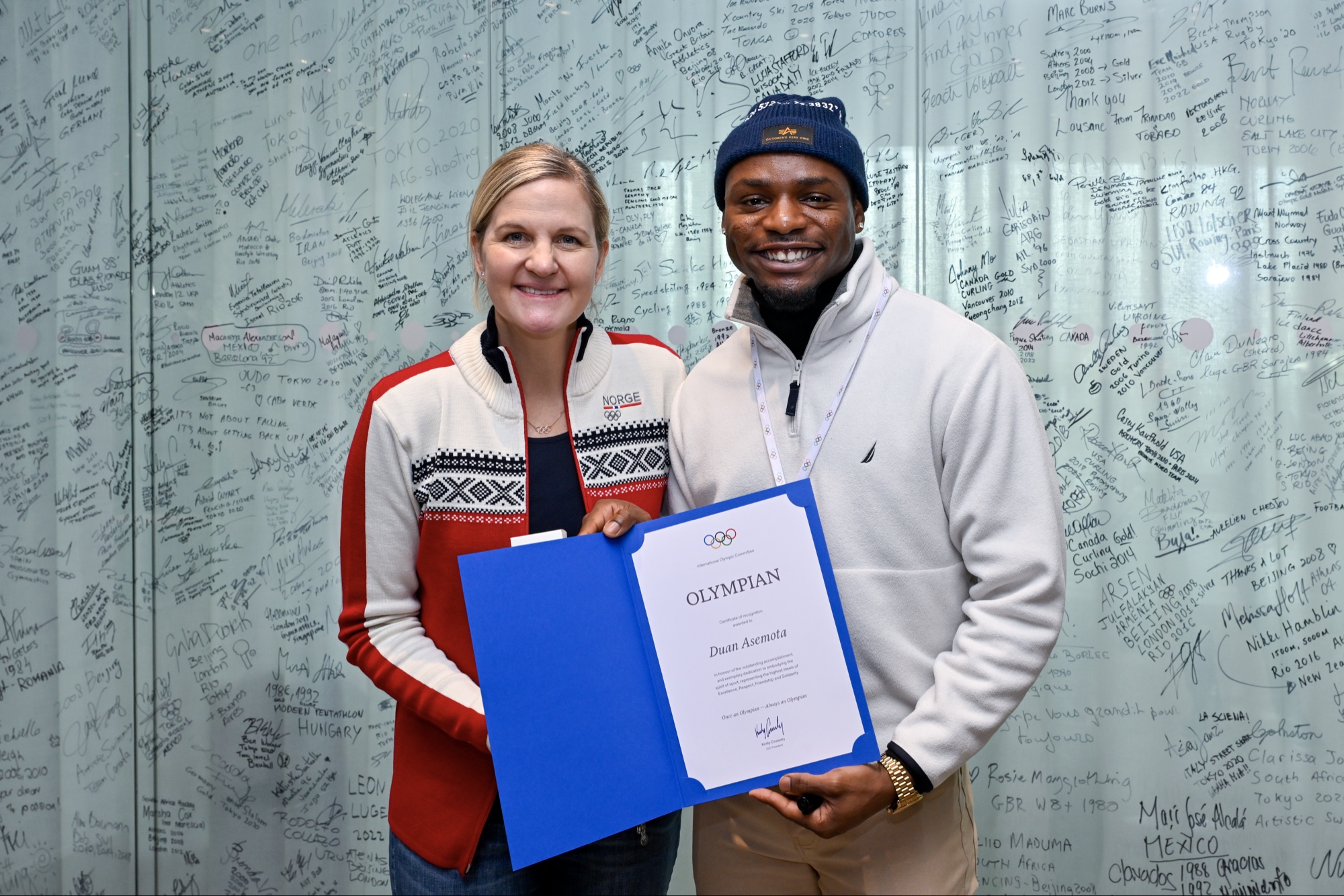 Duan Asemota with IOC President Kirsty Coventry holding the official Olympian certificate at Olympic House in Lausanne, December 2025