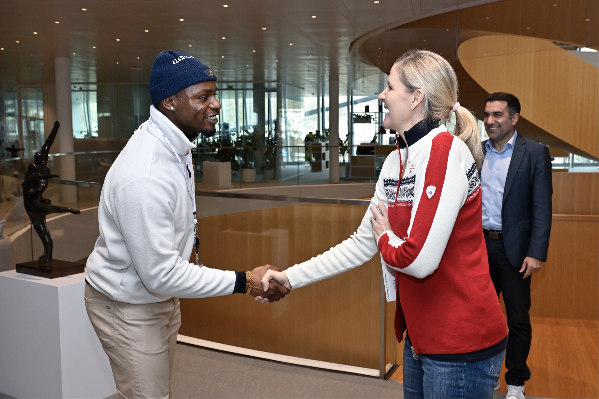 Duan Asemota shaking hands with IOC President Kirsty Coventry inside Olympic House