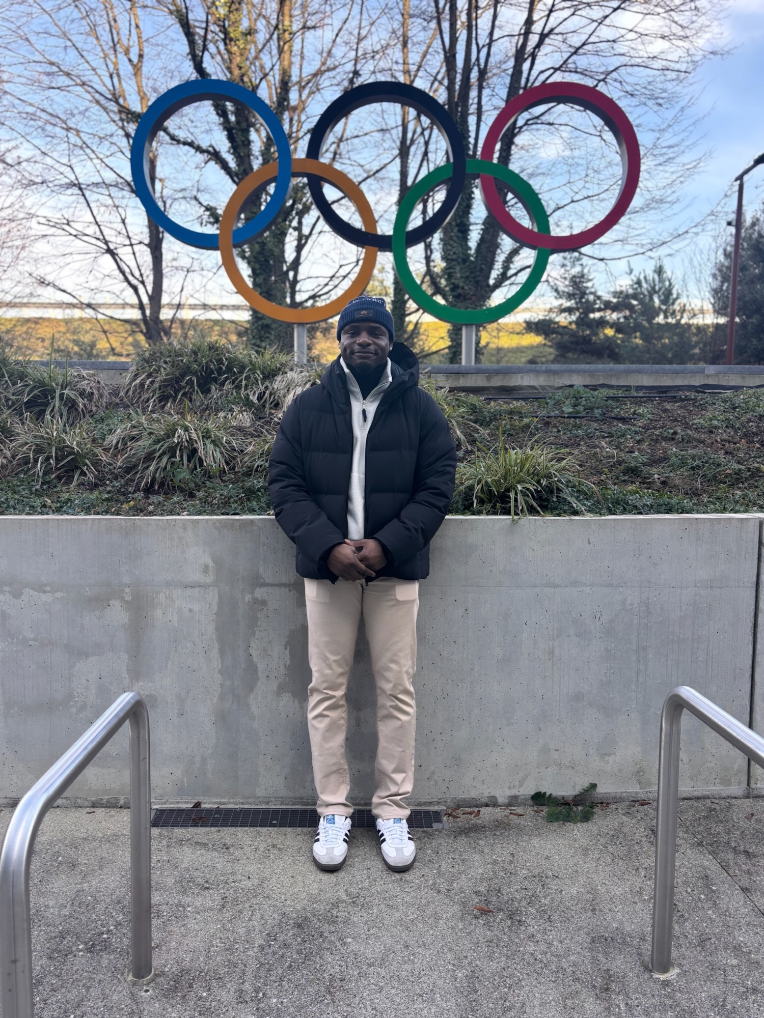 Duan Asemota standing in front of the Olympic rings outside Olympic House in Lausanne