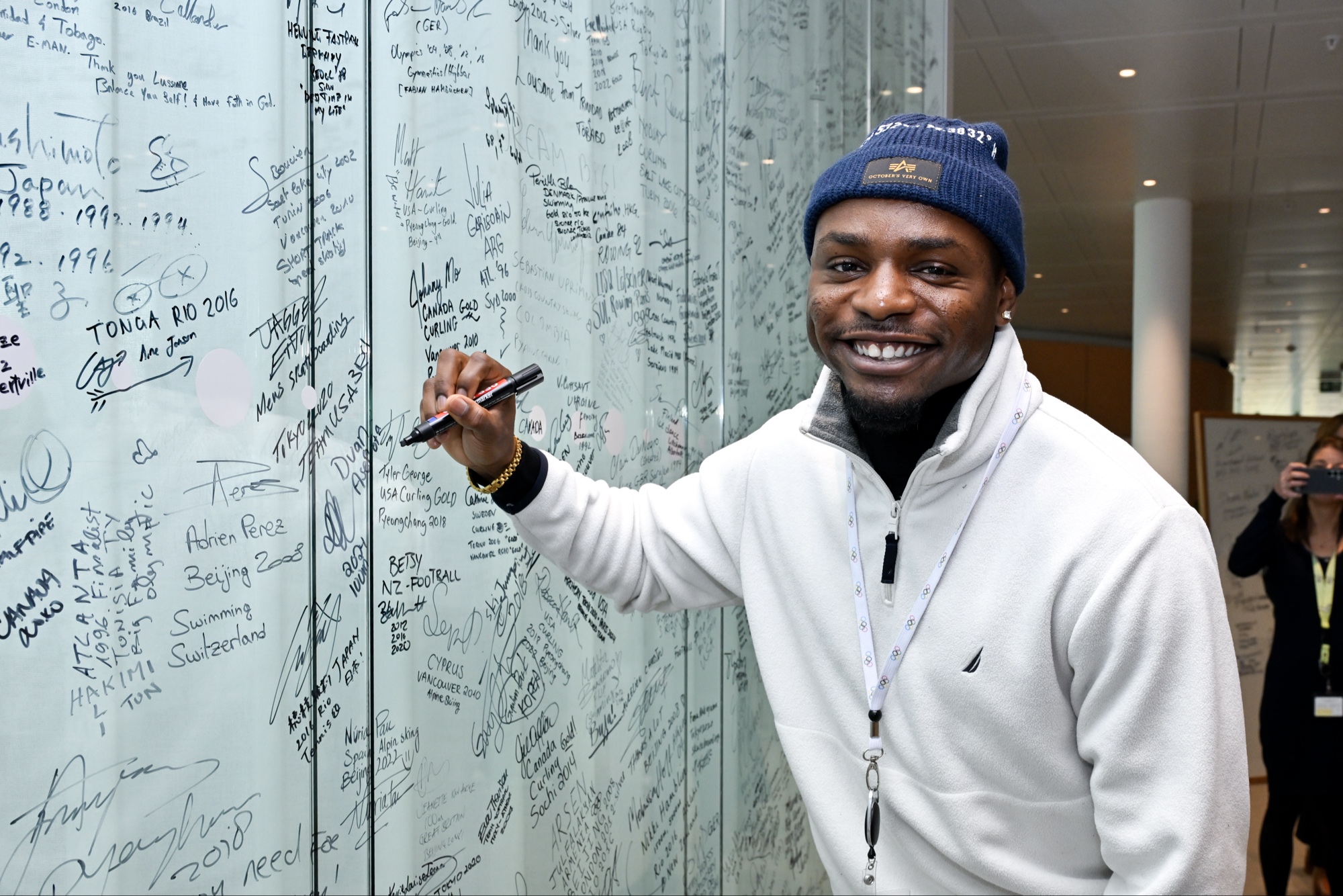 Duan Asemota signing the Olympians' wall at IOC headquarters